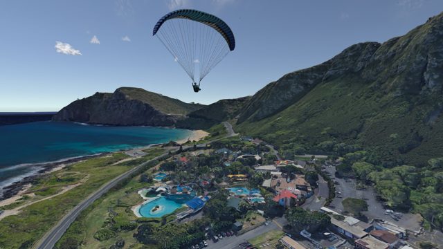 Paraglider over a coastal resort town